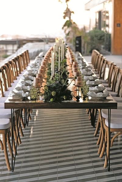 Romantic couple dinner table set directly on the beach at sunset